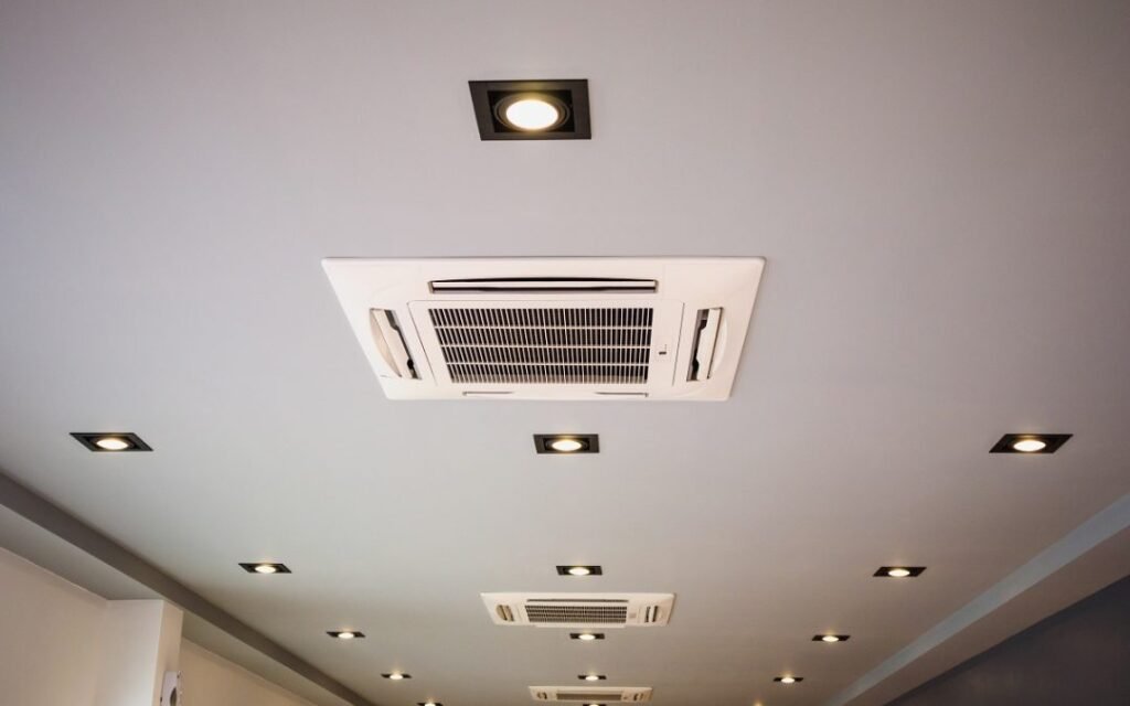 Système de climatisation gainable avec conduits intégrés au plafond et grilles discrètes.