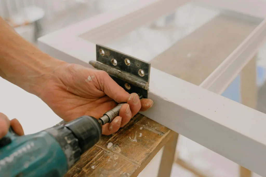 Une personne utilise une perçeuse pour percer un trou pour la rénovation studio